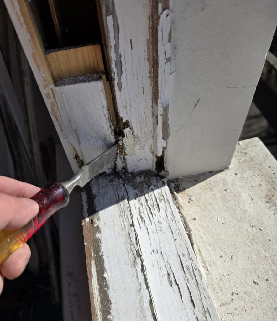 Testing localised rot at the corner of a timber sash window