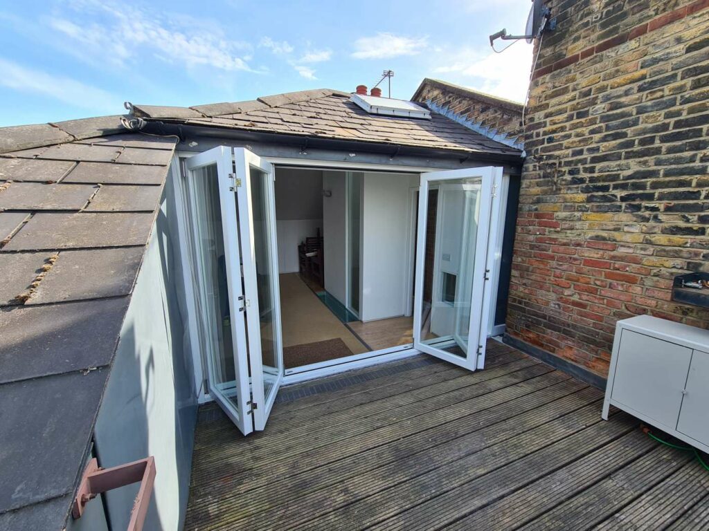 Open timber bifold doors with an external deck and threshold
