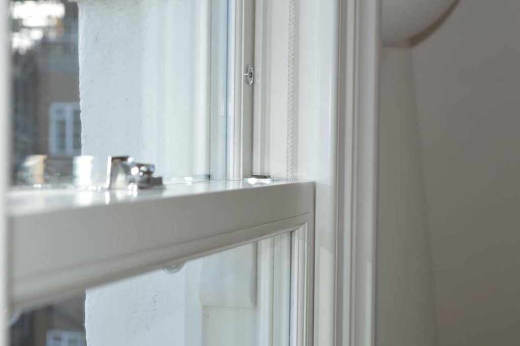 Close-up of a timber sash window frame, meeting rail and sash cord