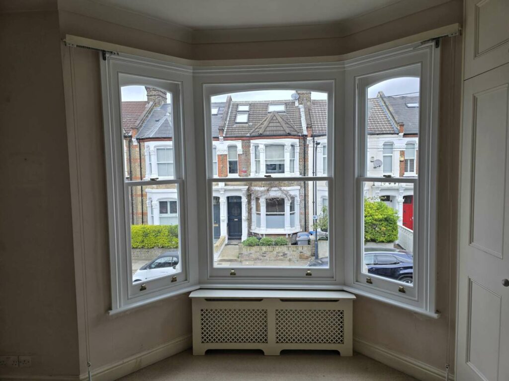 Three timber sash windows in a bay with traditional proportions