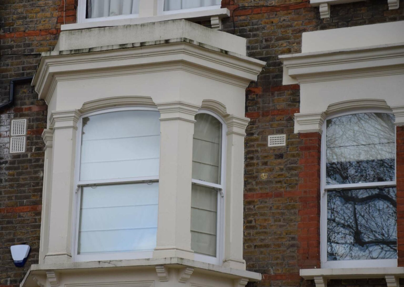 White timber bay sash windows on a London period brick façade