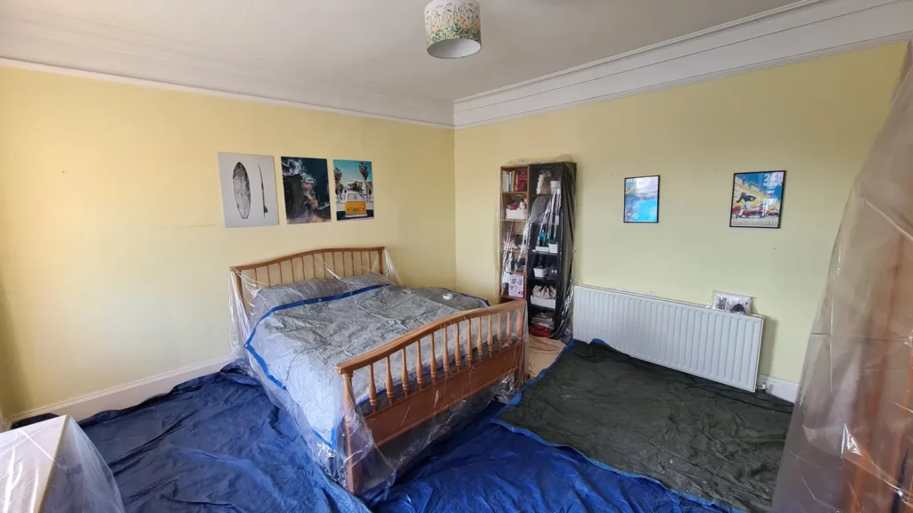 Bedroom floor and furniture protected before window repair