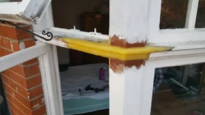 Timber repair in progress around an open sash window