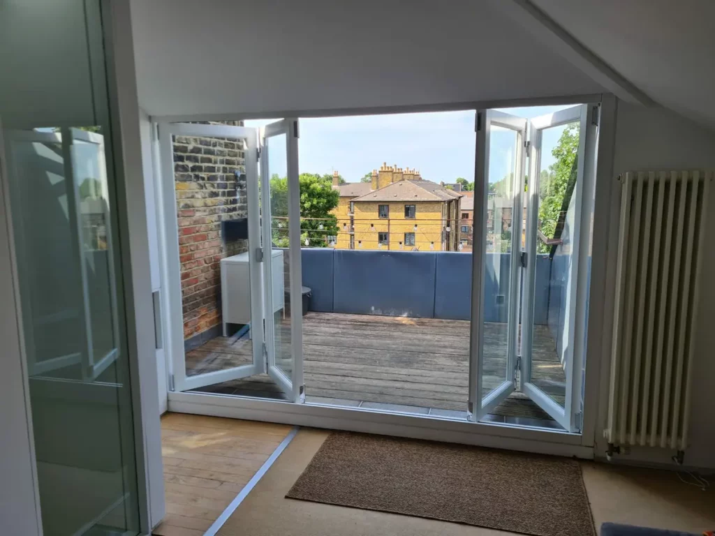 White glazed folding doors opened onto a sunny roof terrace