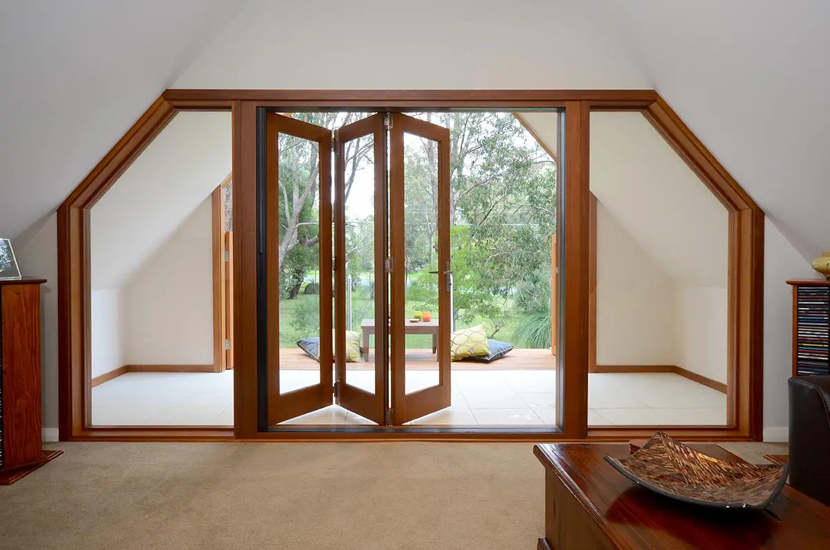 Timber bifold doors with large glazed side panels opening onto a garden terrace