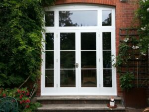 White-painted French doors with glazed sidelights and a transom